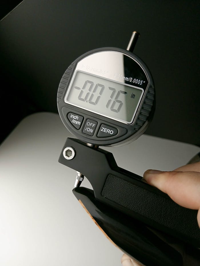 Detailed view of a digital micrometer measuring 0.076 inches in a controlled environment.